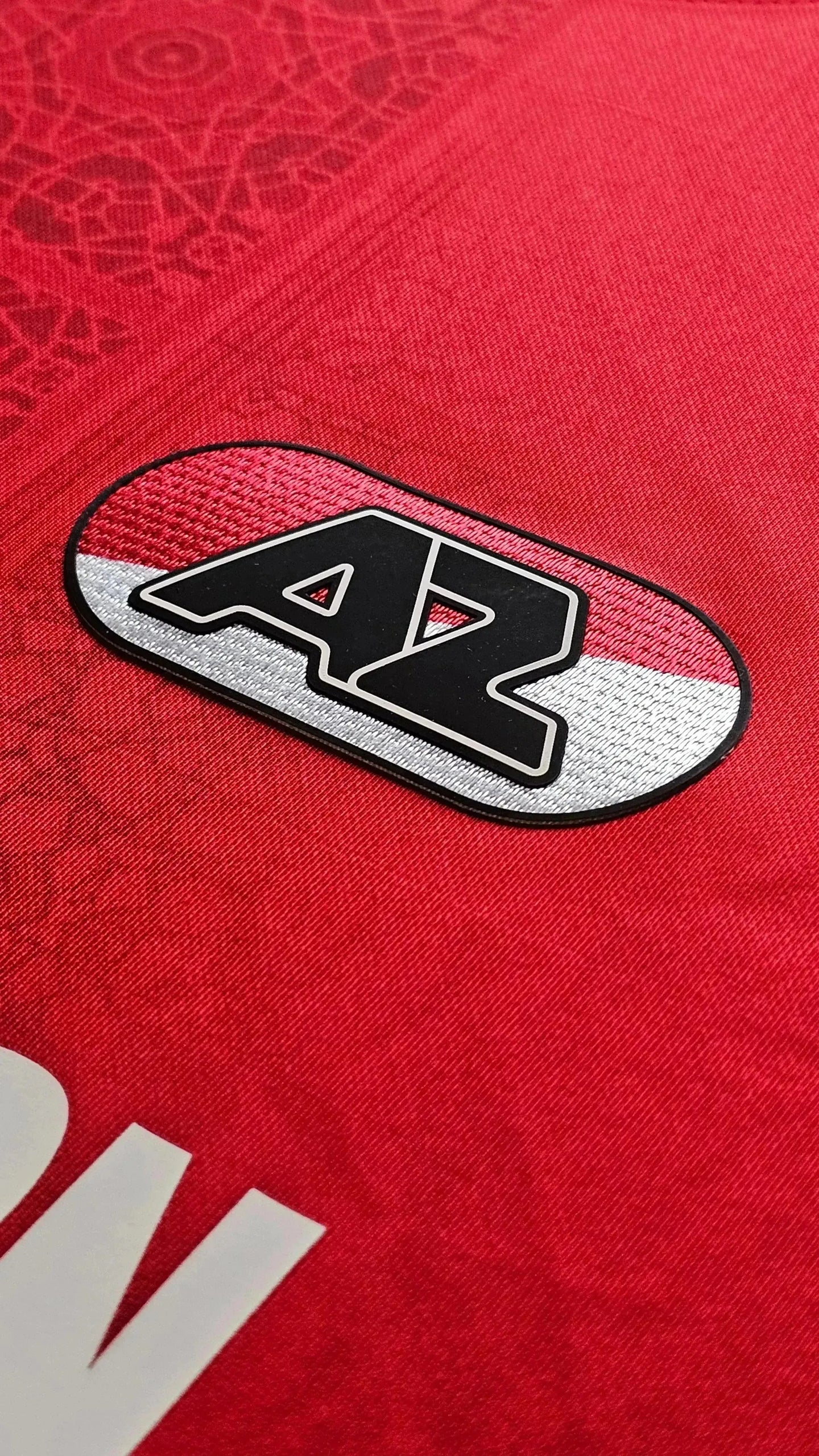 Crest detail featuring AZ logo in black and white on red background.
