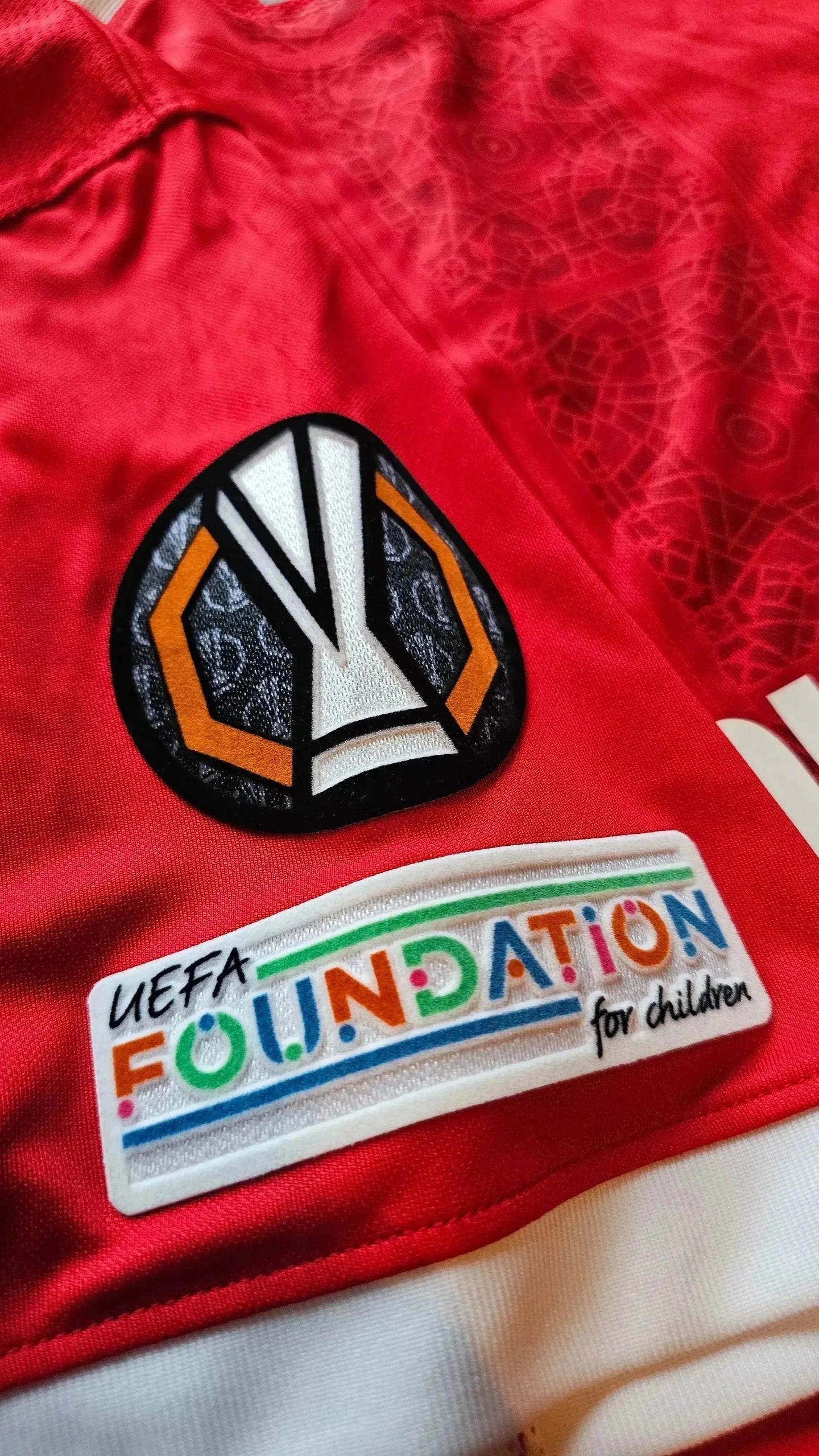 Crest detail featuring UEFA Europa League logo and UEFA Foundation for children text.