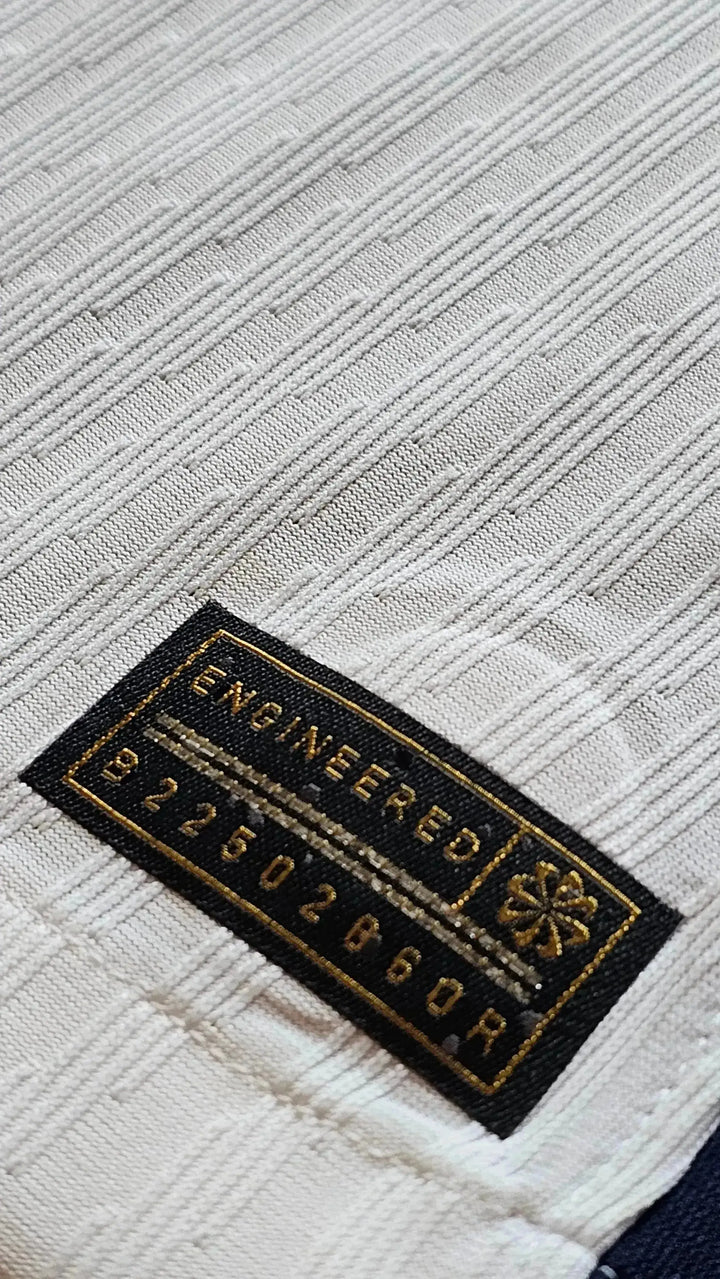 Detailed view of the white textile pattern with an embroidered label reading 'ENGINEERED 922502860R'.