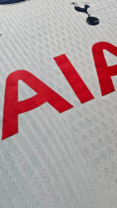 Detail view highlighting the red 'AIA' sponsor text on a Tottenham Hotspur football shirt.