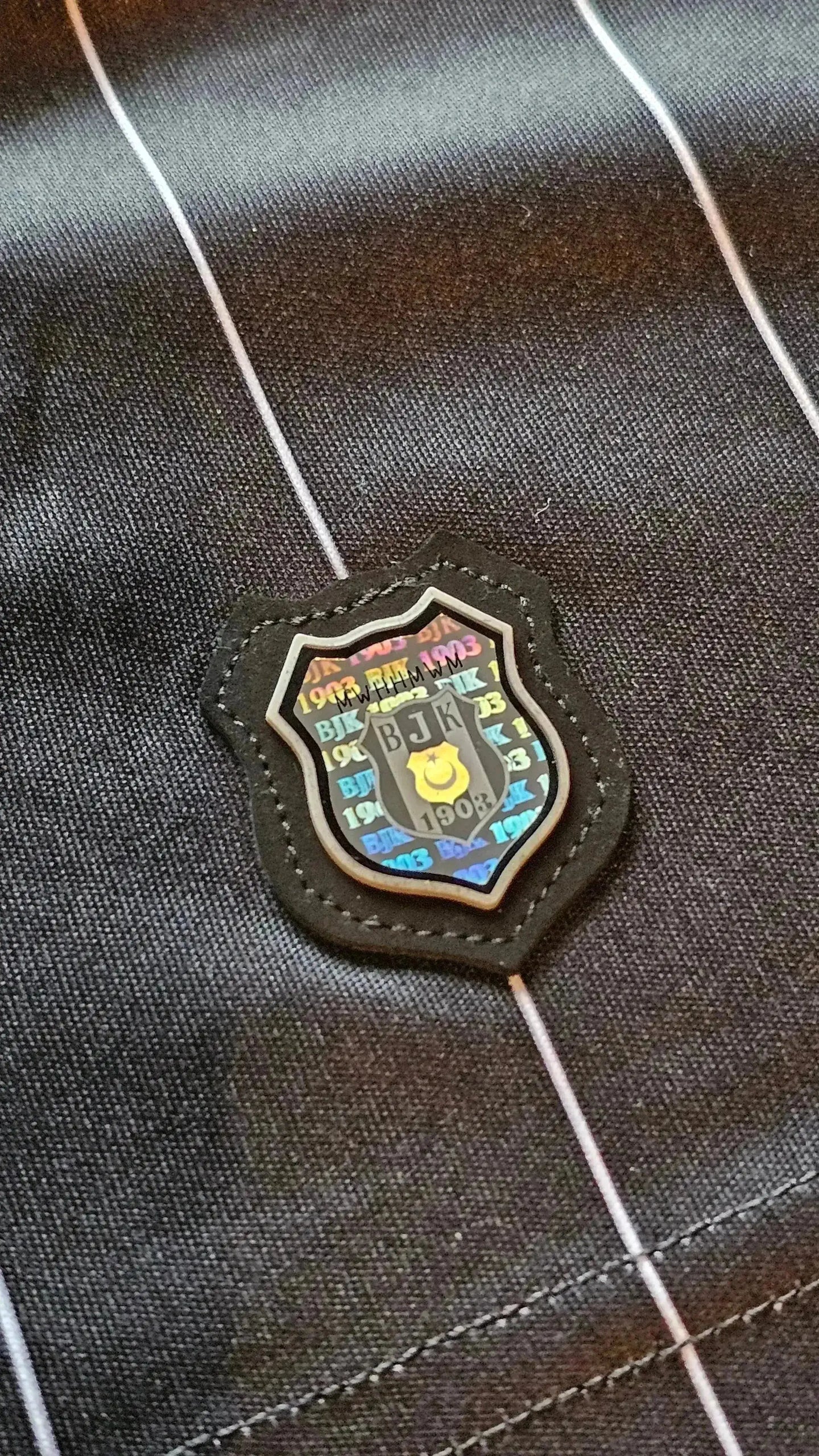 Crest detail of Beşiktaş J.K. featuring 'BJK 1908' in vibrant colors.