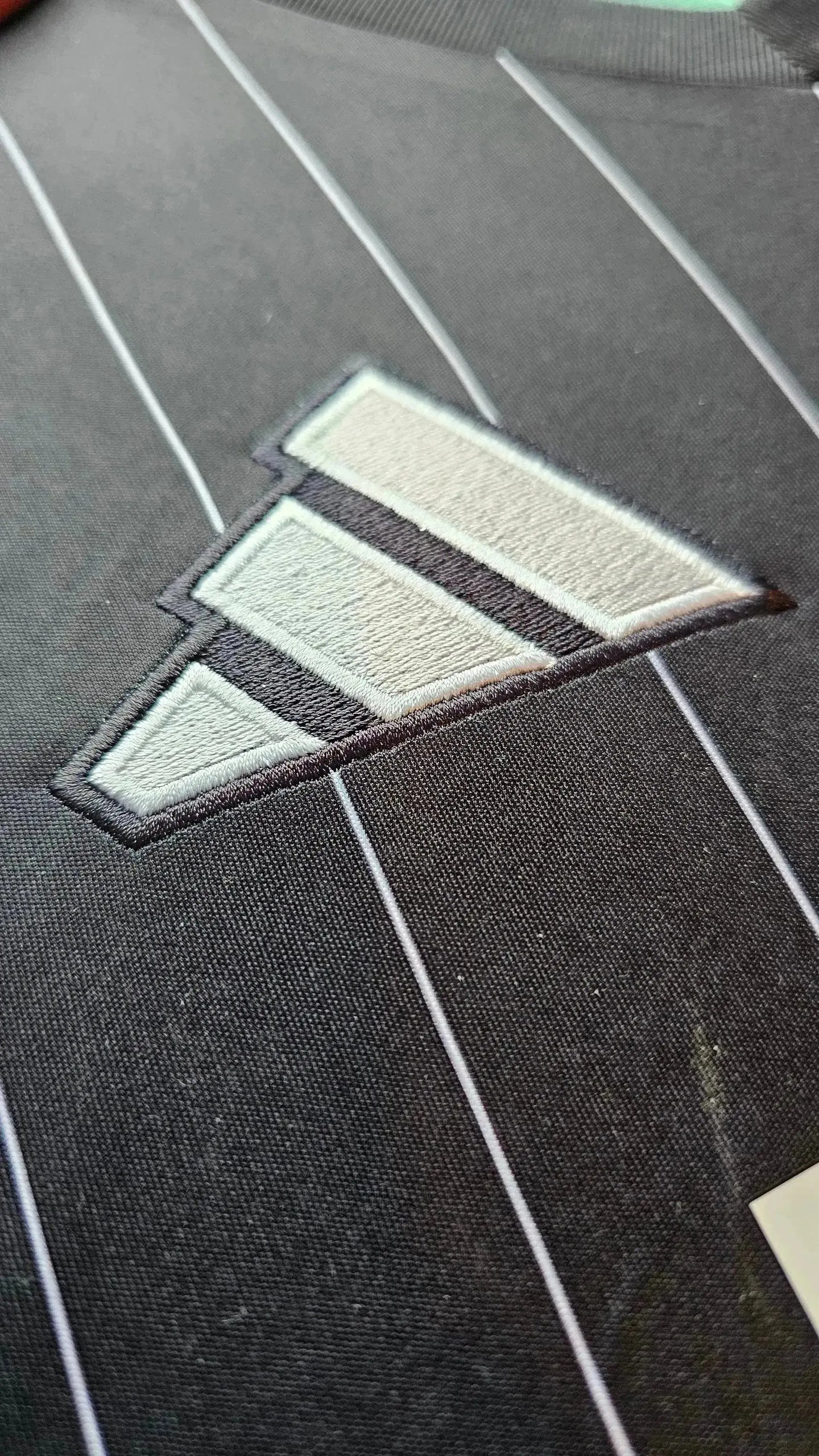 Crest detail showing Beşiktaş logo with white and grey colors on a black background.