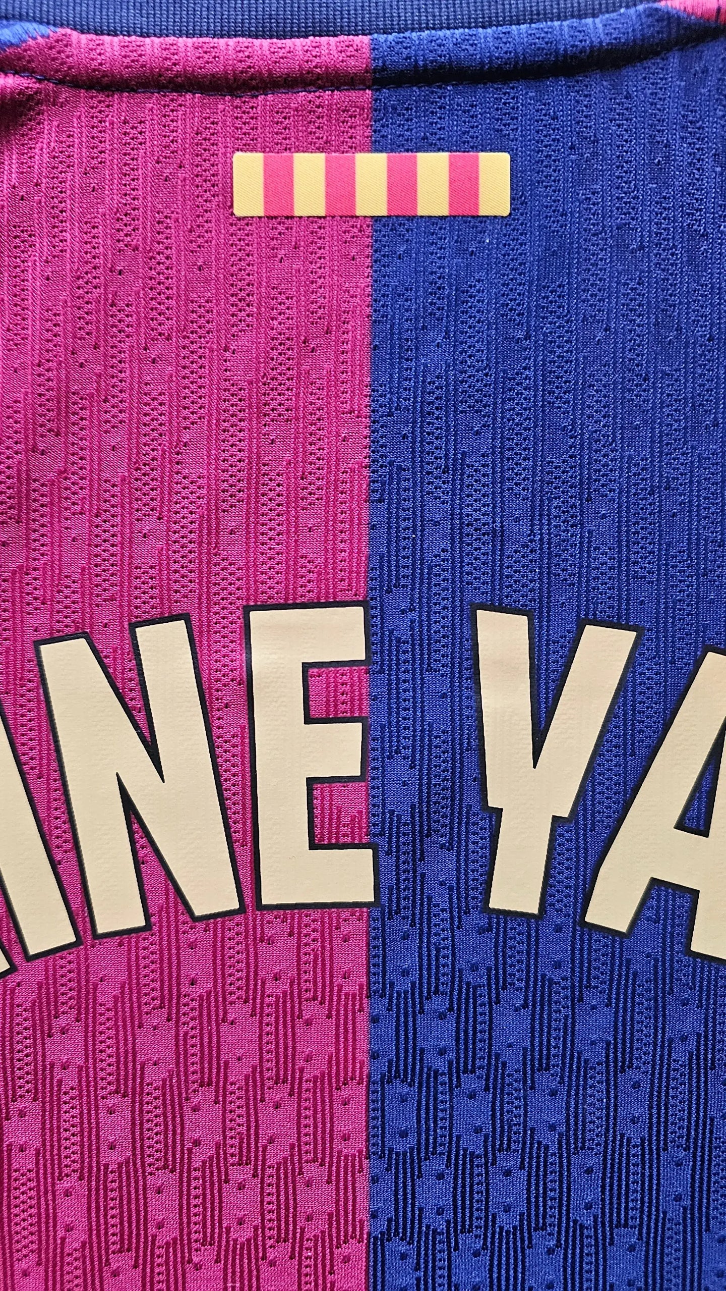 Back view showing the name YAMAL in large cream letters and pink and blue striped fabric pattern.