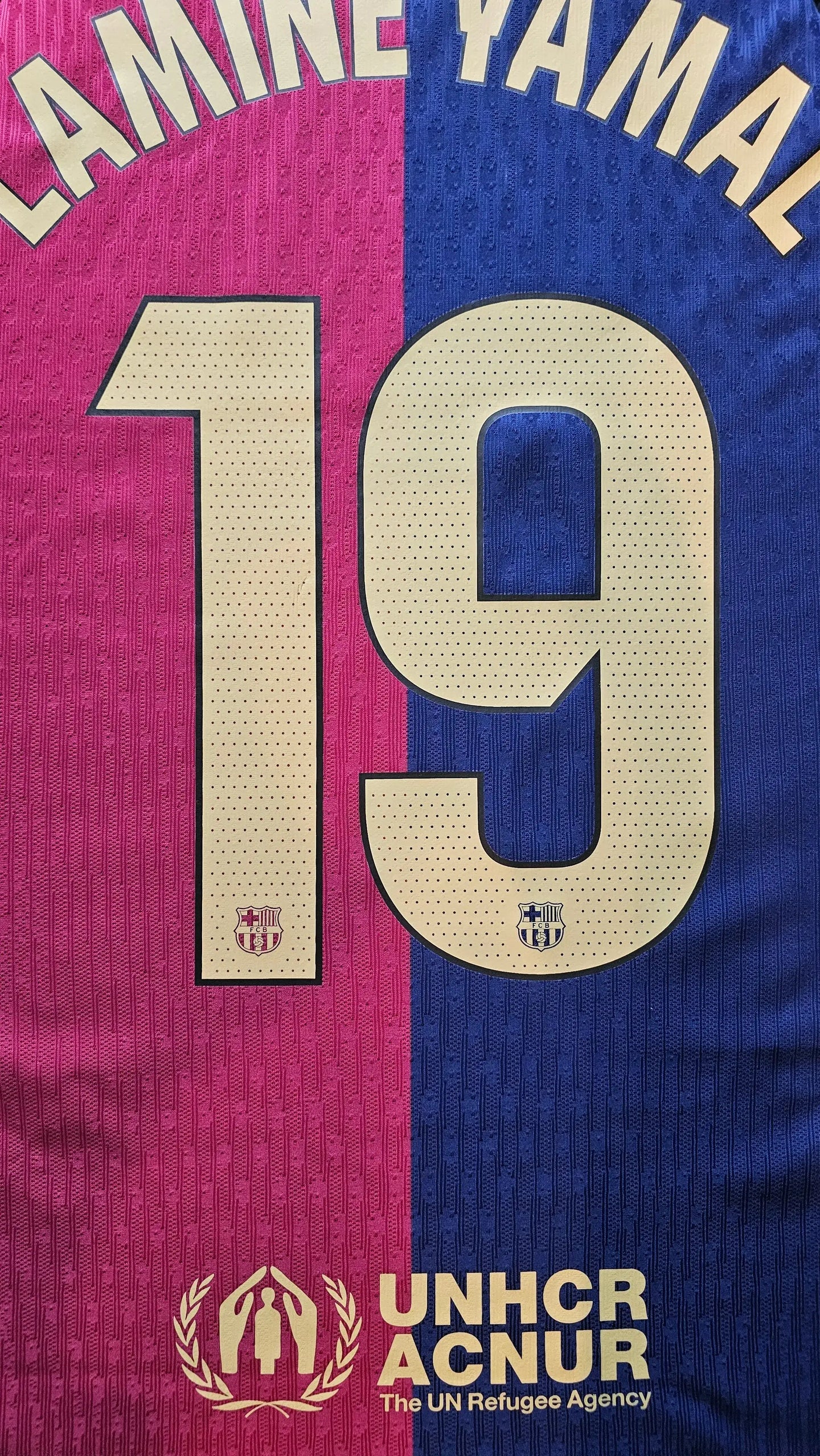 Back view showing Lamine Yamal with No. 19, featuring blue and pink sections, and UNHCR logo.