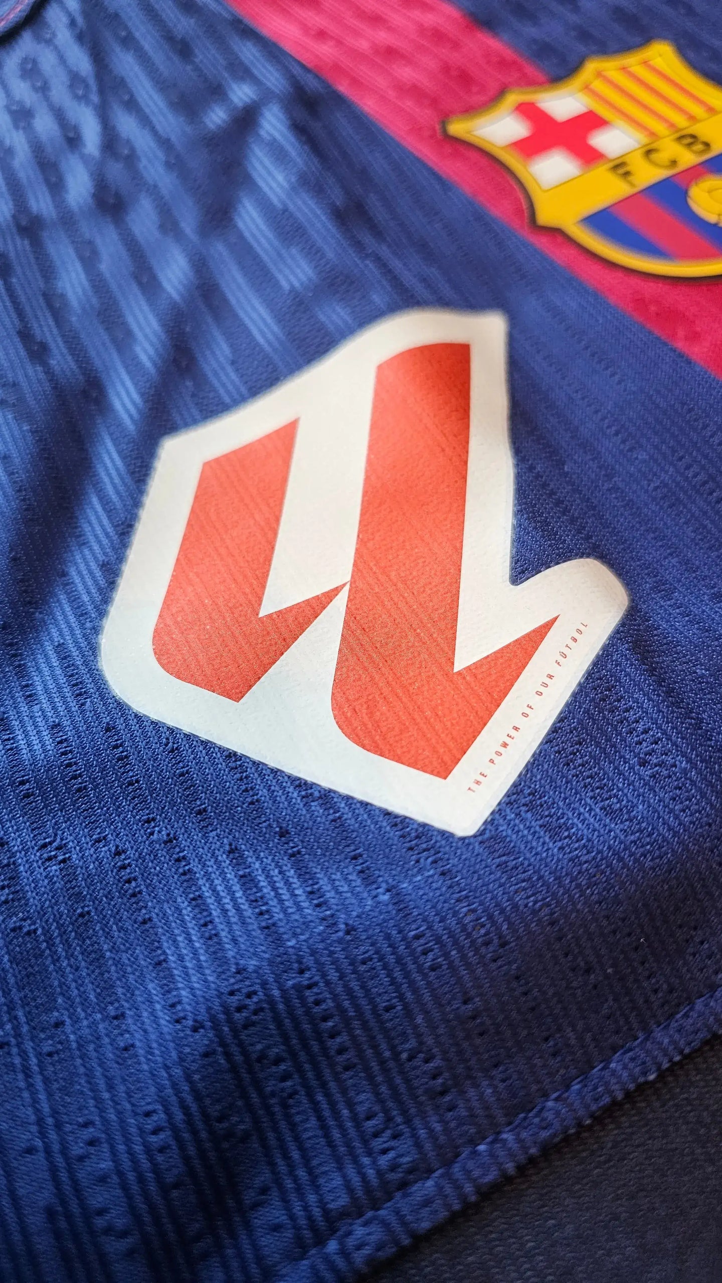 Close-up showing FC Barcelona crest, red and blue colors, and printed sponsor logo with text.