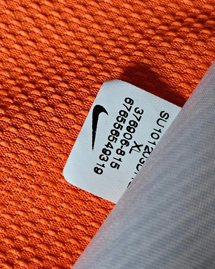 Nike tag showing product details on orange fabric of Wesley Sneijder 10 Holland signed football shirt.