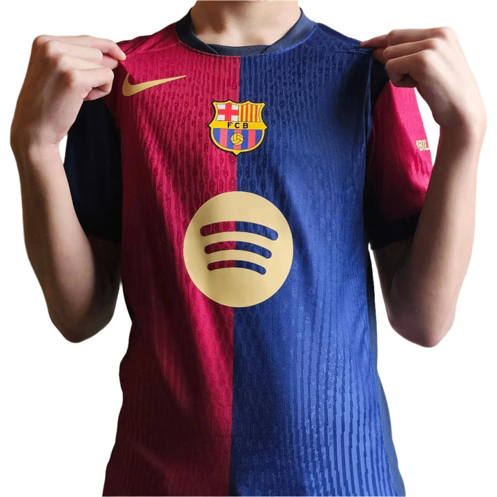 Front view of Barcelona football shirt featuring crest and Spotify logo in gold.
