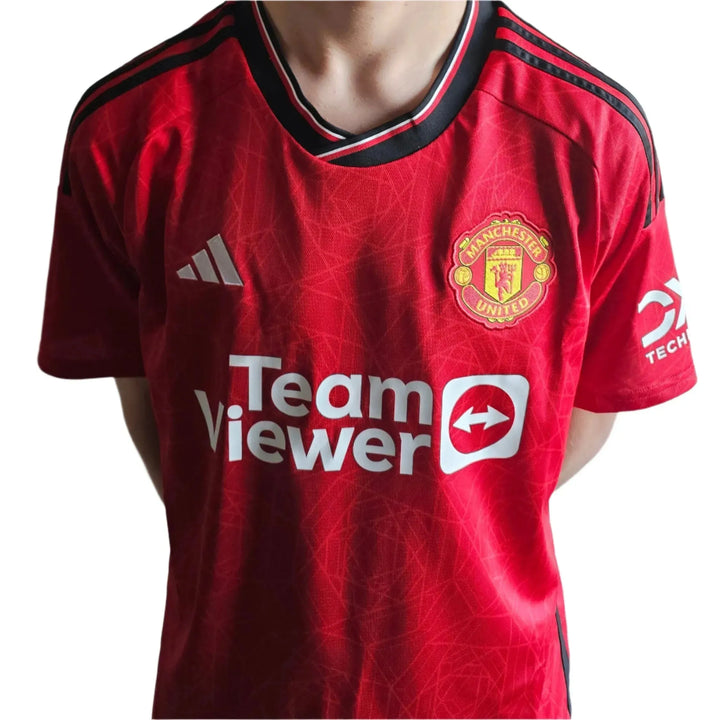Front view of a red Manchester United football shirt featuring the crest and TeamViewer sponsor.