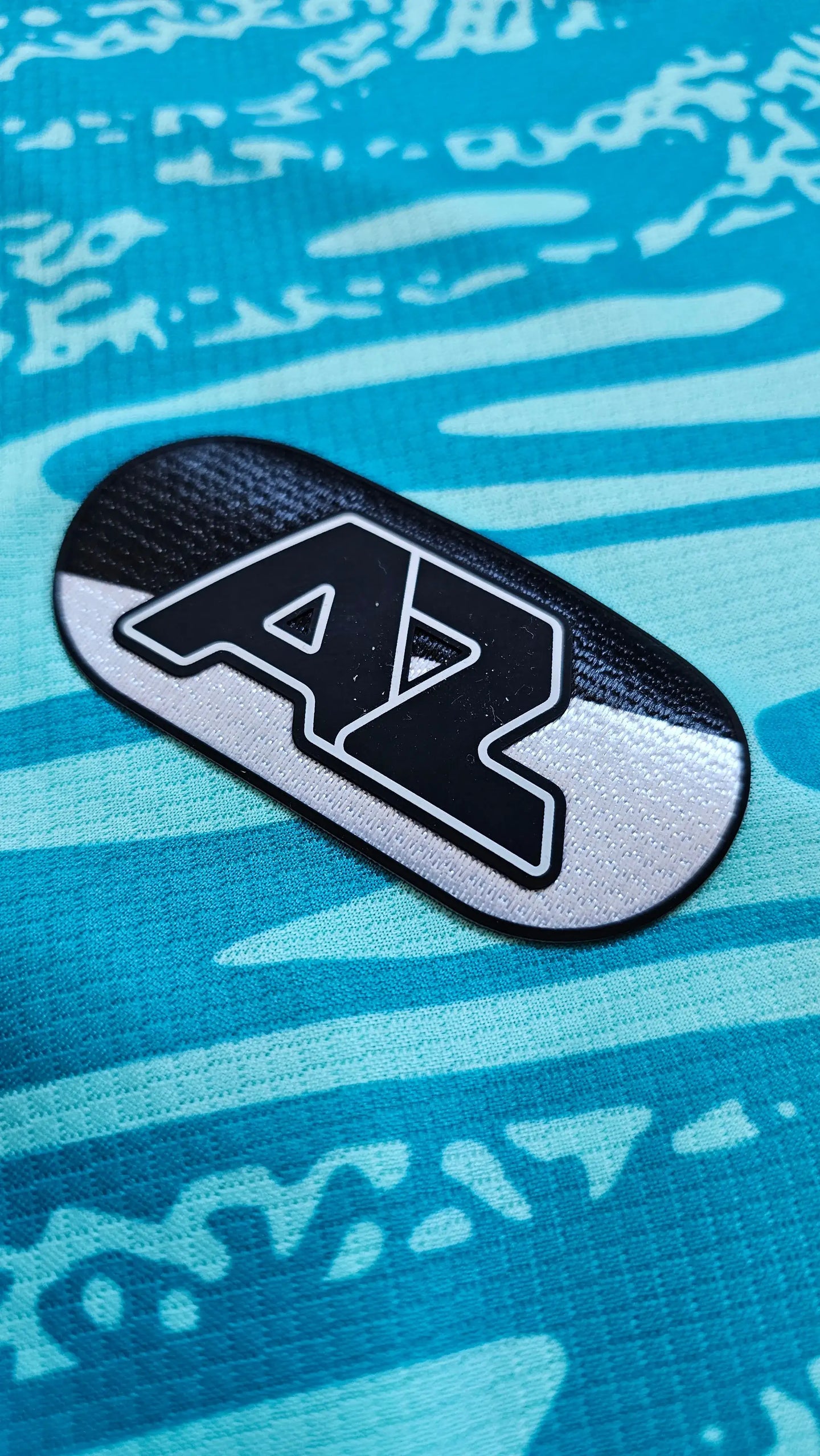 AZ Alkmaar crest detail featuring a black and white design on a blue background.