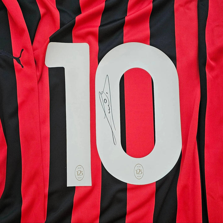 Detail view showing No. 10 and Ruud Gullit's signature on a red and black AC Milan shirt.
