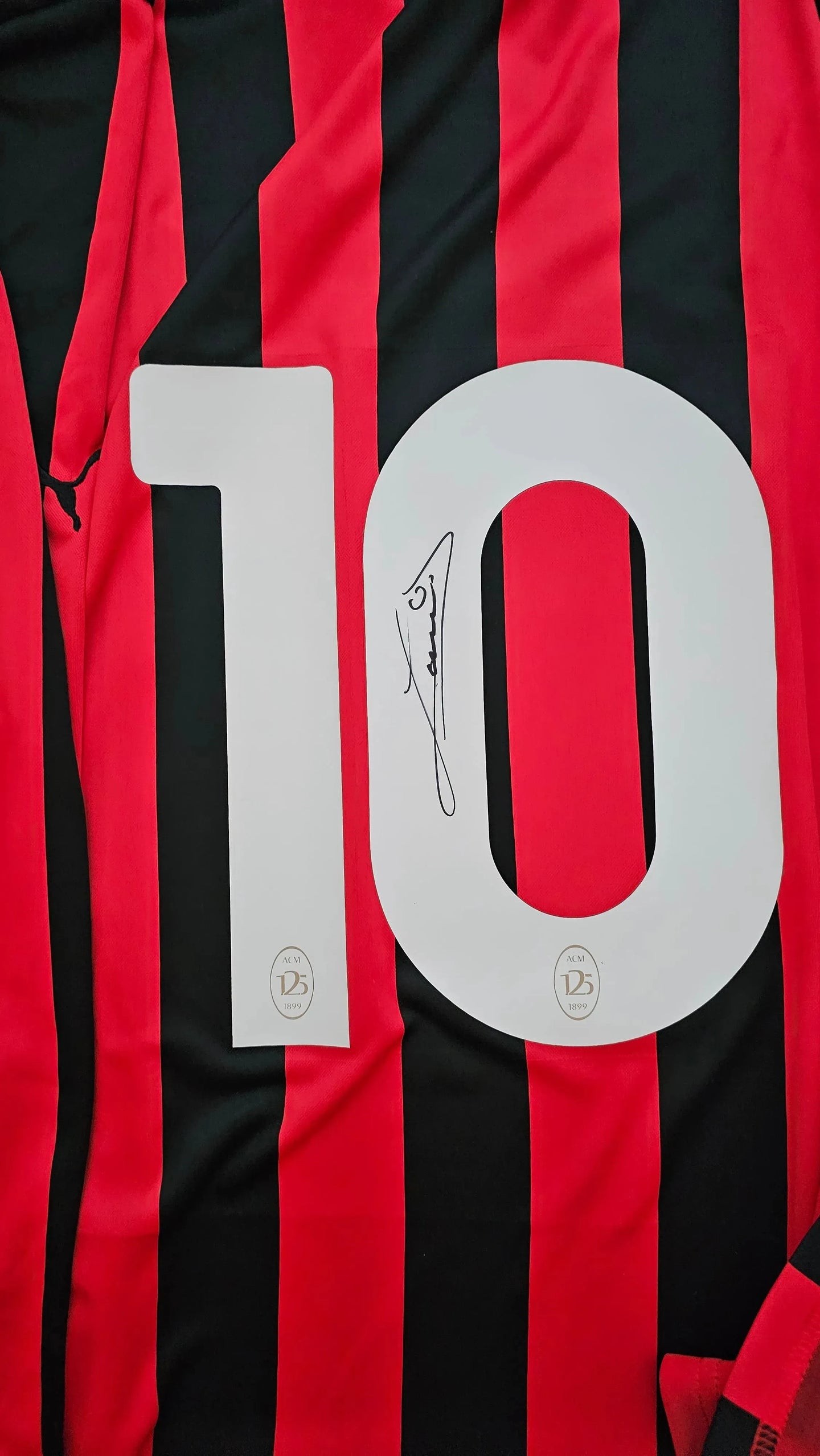 Red and black striped football shirt with No. 10 and Ruud Gullit signature detail.