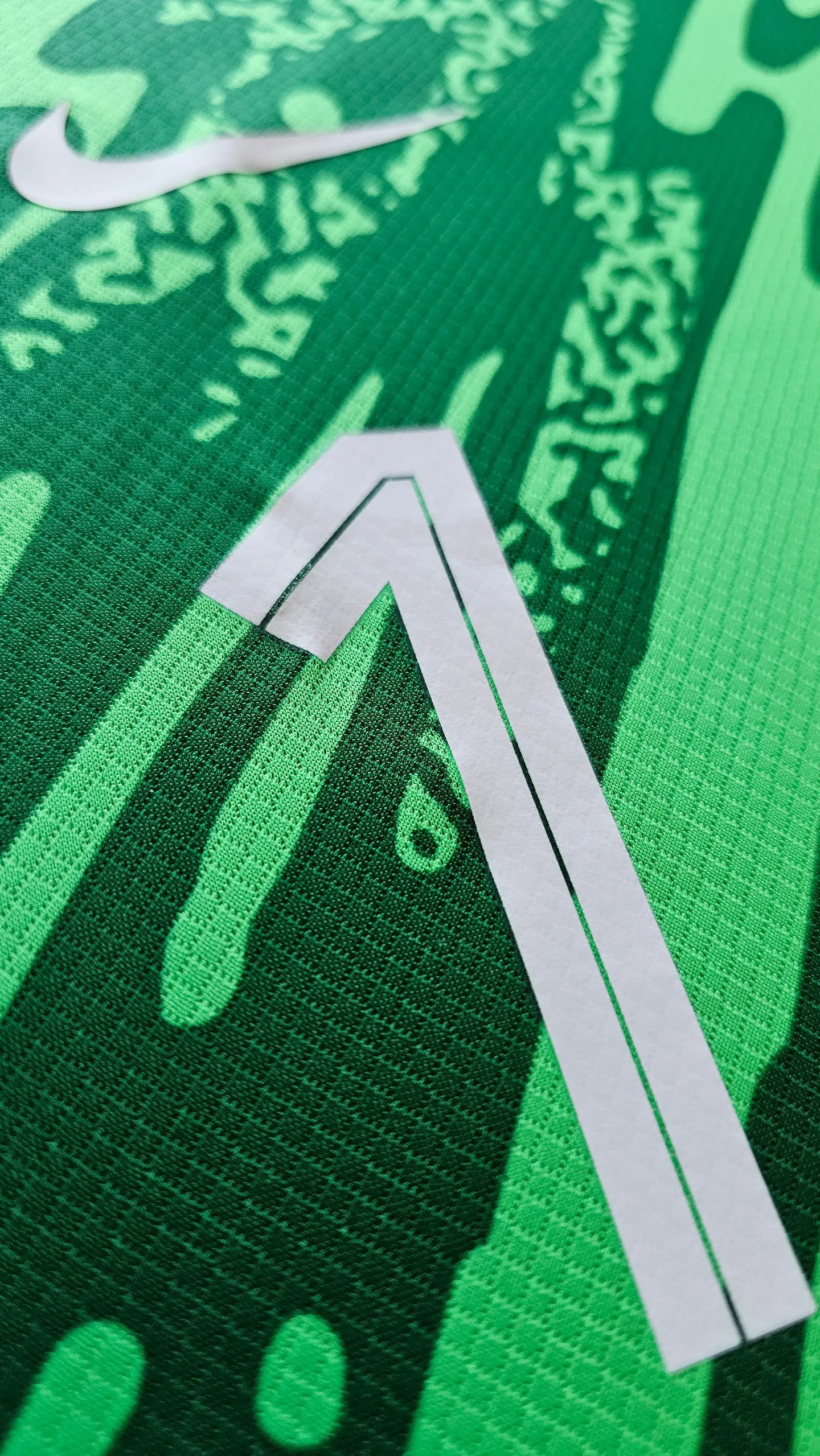 Detail of Bart Verbruggen 1 on a green football shirt with Nike logo and distinctive graphic design.