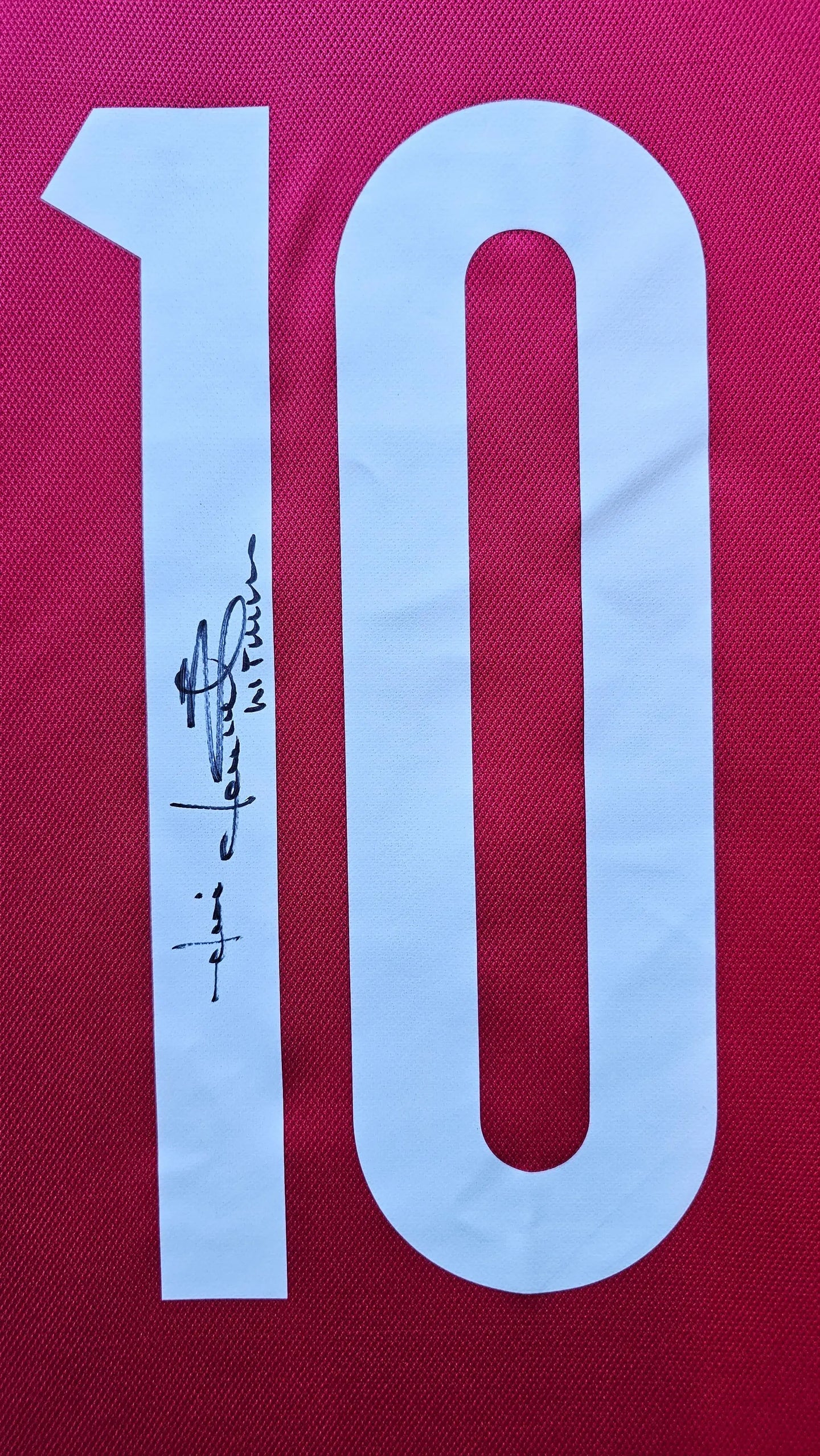 Detail view showing No. 10 and Jari Litmanen's signature on a red football shirt.