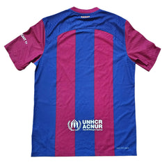 Back view of blue and red Barcelona 2024 ROLLING STONES shirt featuring UNHCR logo.