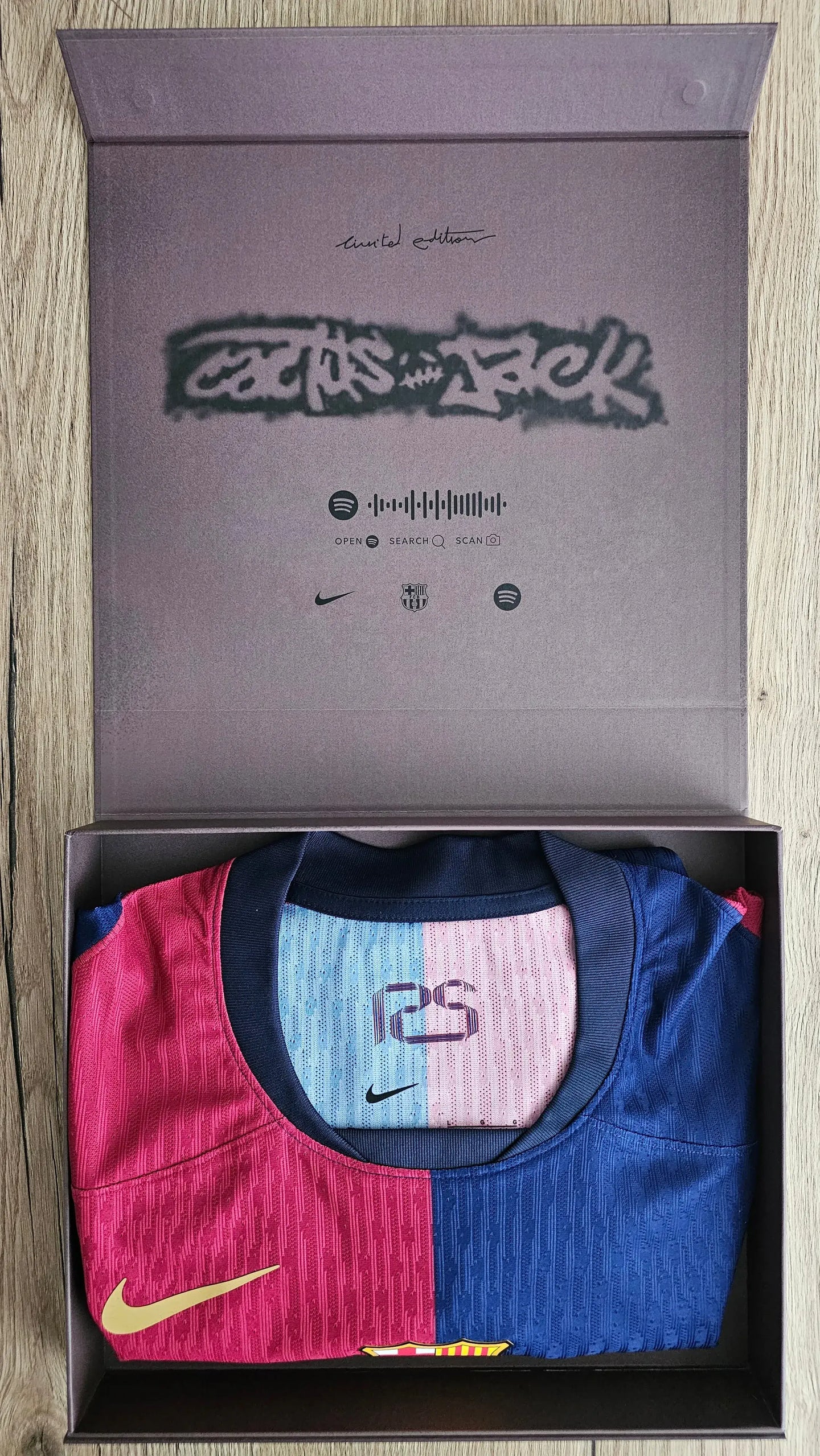 Box containing a football shirt with Nike logo on a wooden surface
