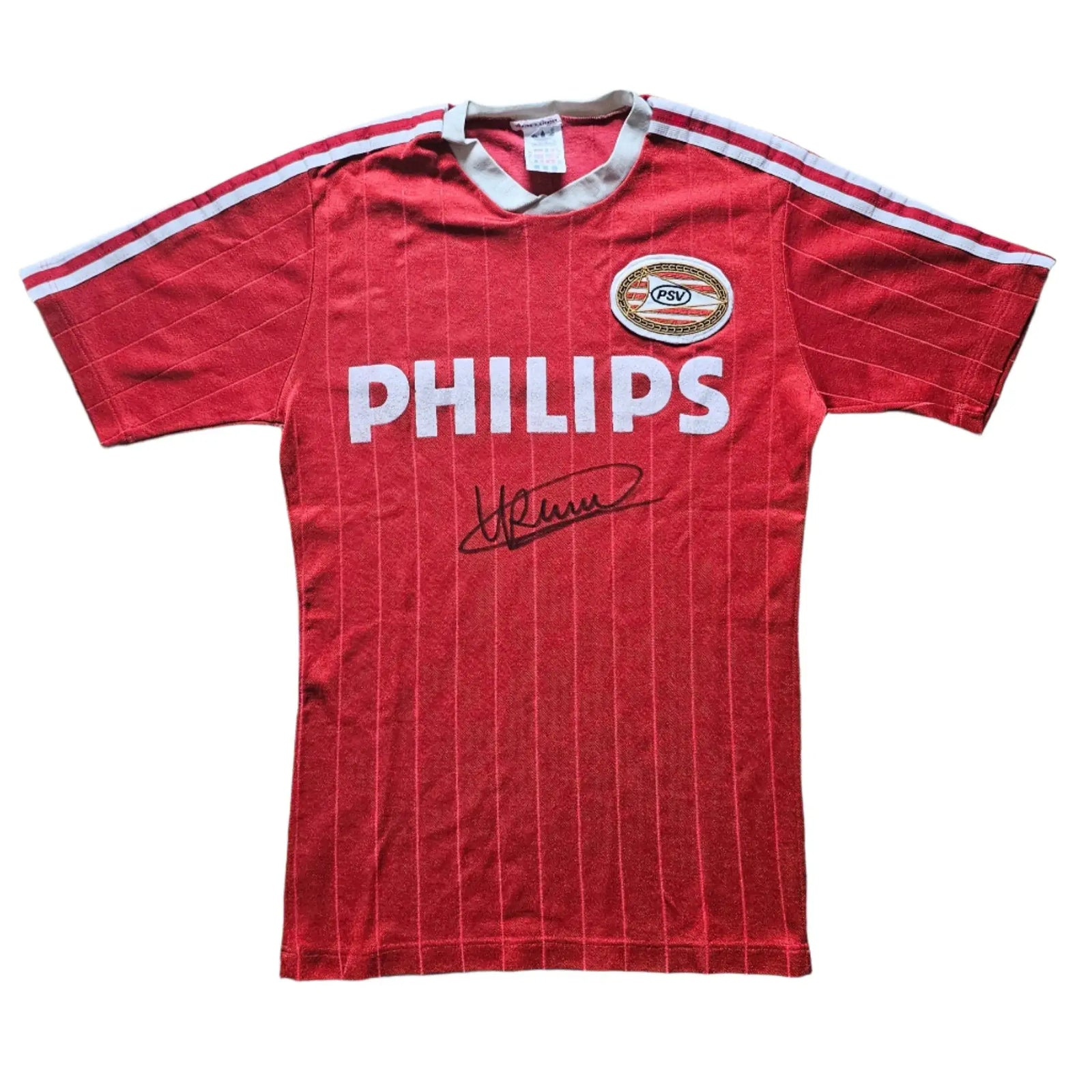 Front view of a red PSV Eindhoven football shirt featuring a visible crest and Ronald Koeman's signature.