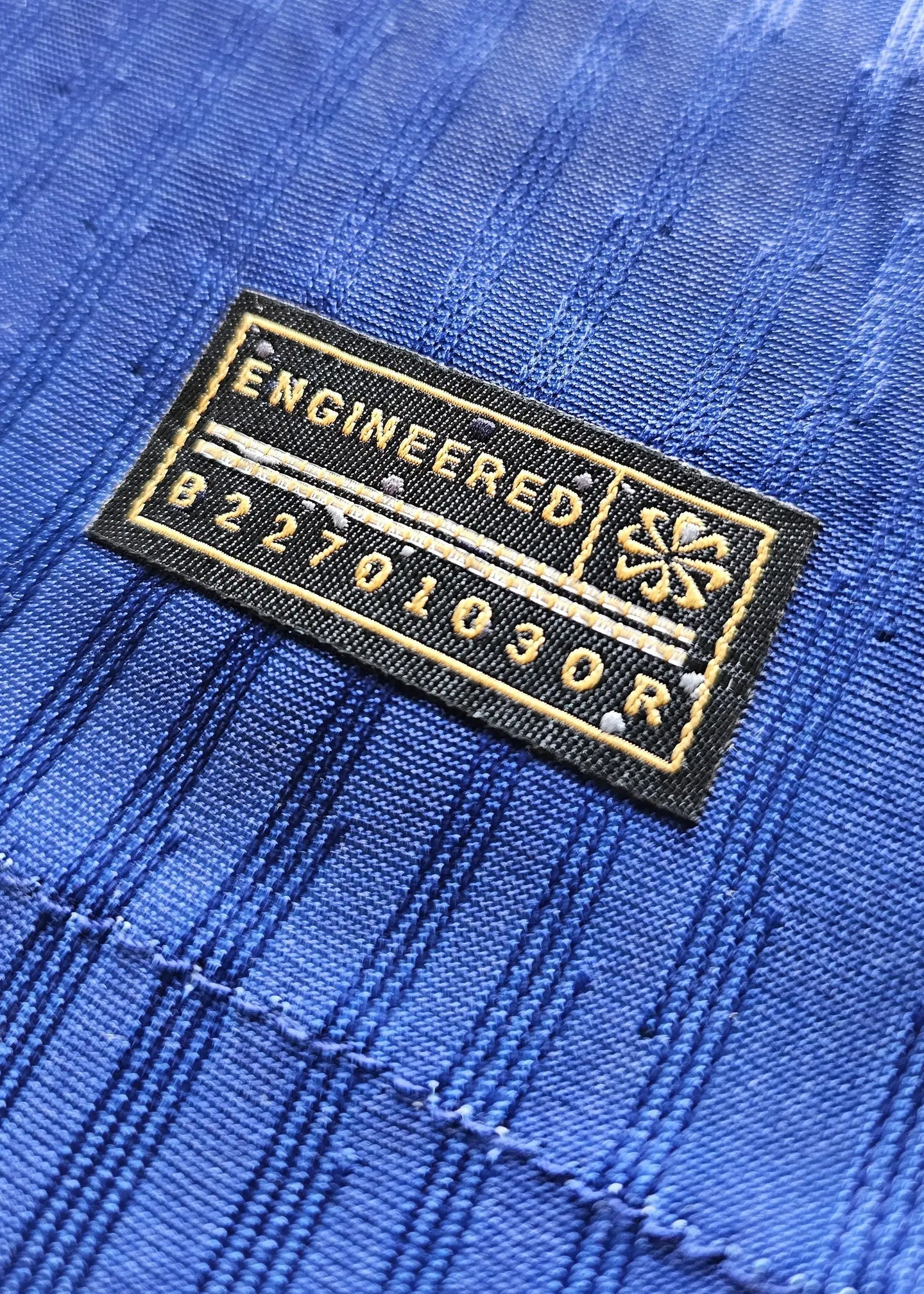 Close-up of the ENGINEERED patch and label on the blue Barcelona soccer jersey.