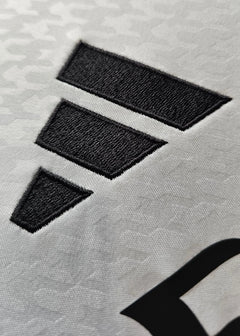 Close-up of the adidas logo on the white Real Madrid football shirt.