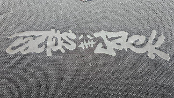 Close-up view showing signature detail of Travis Scott on FC Barcelona 2025 black football shirt.