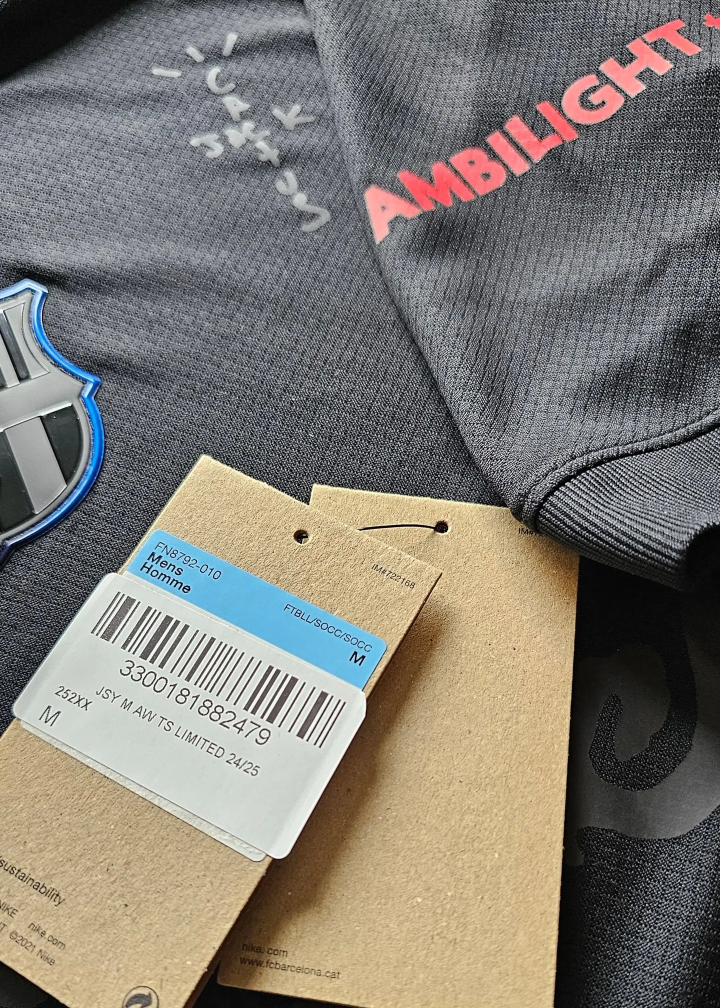 Signature detail on FC Barcelona 2025 Travis Scott black football shirt with AMBILIGHT branding.
