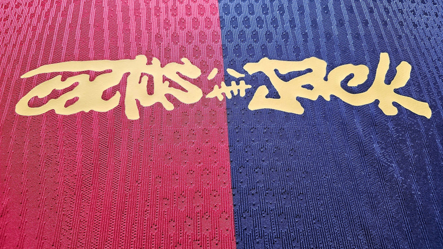 Close-up detail displaying the gold text 'CACTUS JACK' on the pink and blue fabric.