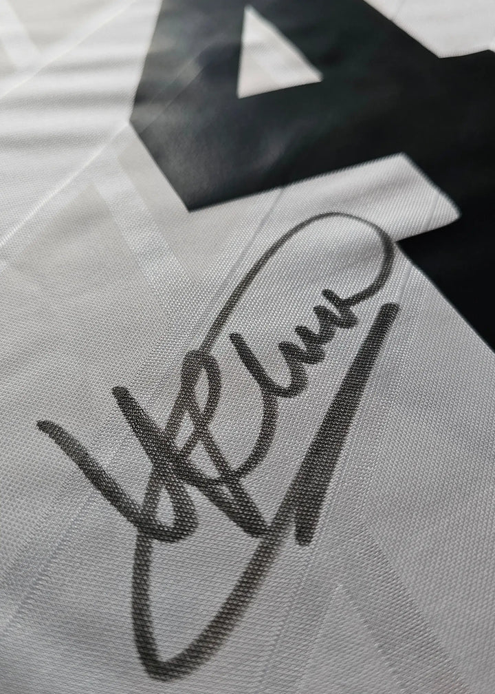Close-up view showing signature on white football shirt with No. 4.