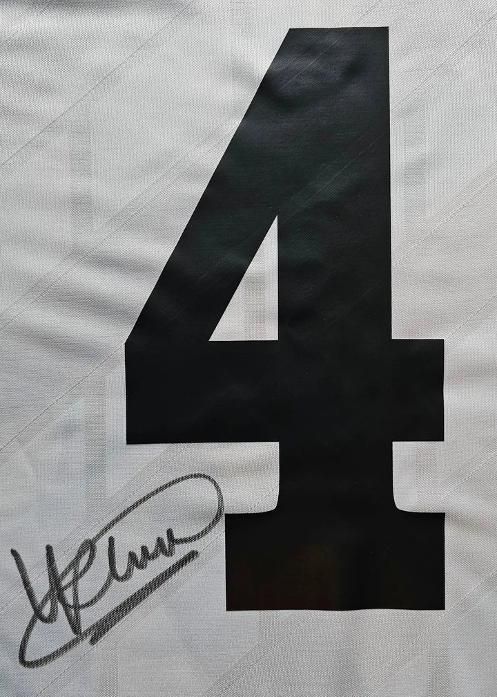 Close-up of No. 4 with signature detail on a white football shirt.