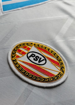 Crest detail showing the PSV badge featuring red and yellow stripes on a white background.