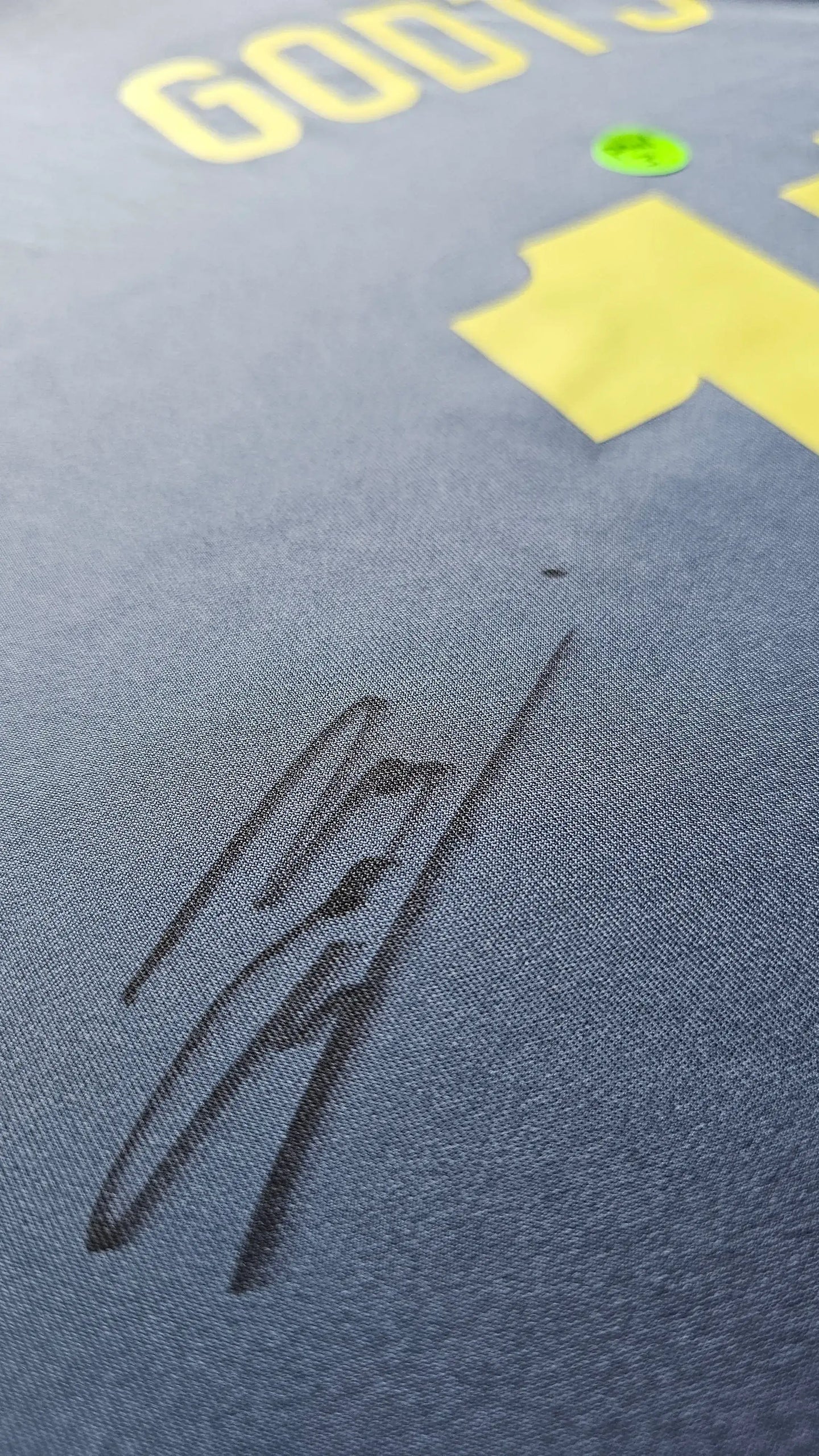Close-up view of signature on Mika Godts 11 Ajax Away Shirt with yellow lettering.