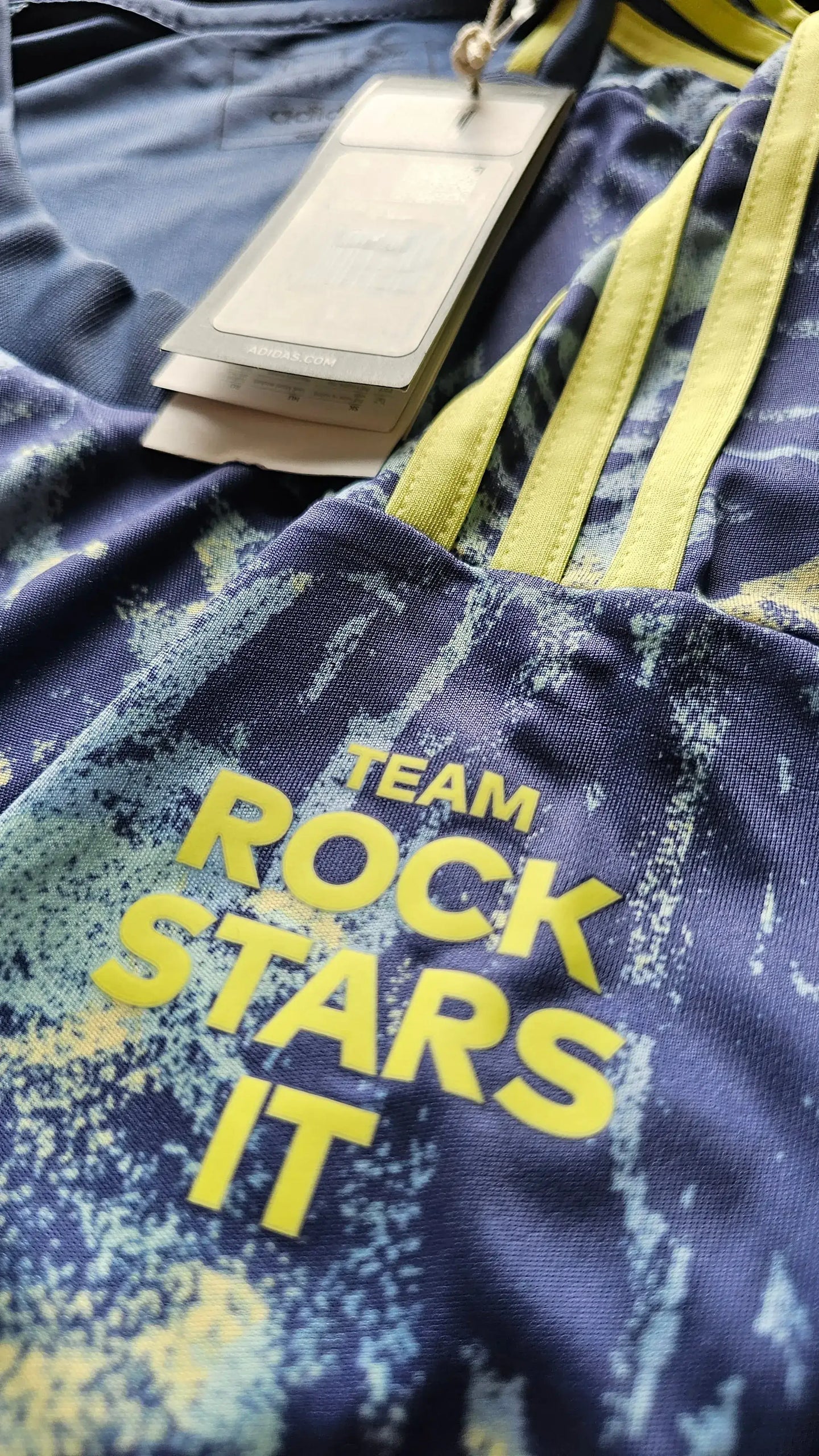 Close-up showing signature detail with "TEAM ROCK STARS IT" in yellow on blue fabric.