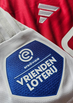 Close-up view of the AFC Ajax crest with 'VRIENDEN LOTERIJ' and 'eredivisie' on the sleeve.
