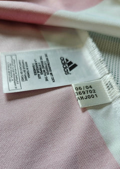 Visible adidas tag showing care instructions and product details on signed football shirt.