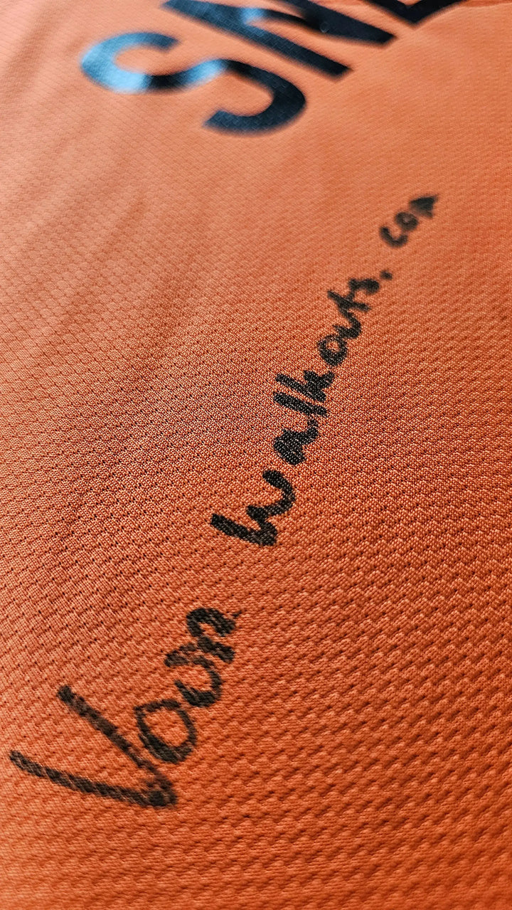 Close-up of the signature detailing on the orange football shirt from Walkouts.com.