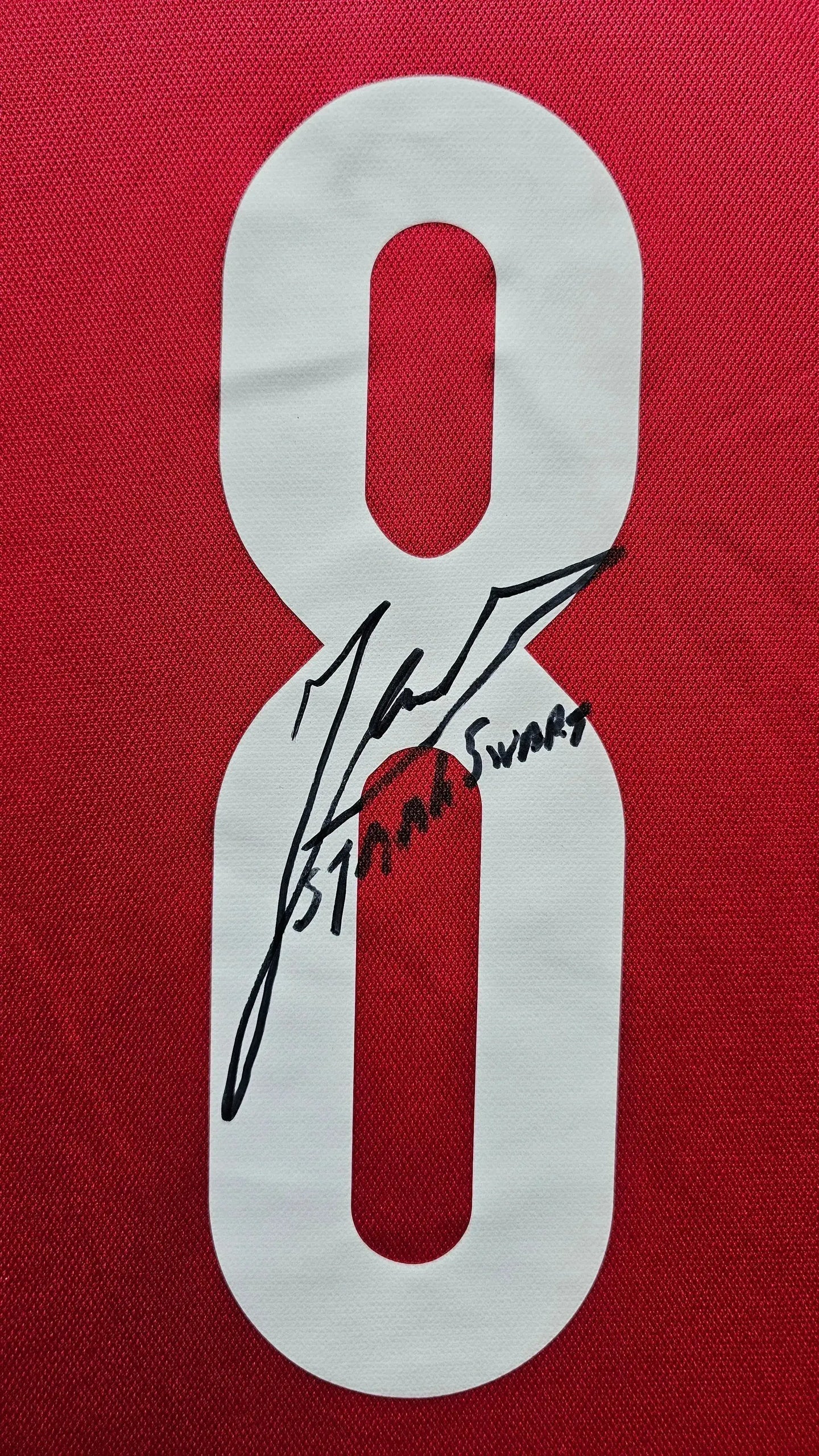 Close-up of No. 8 with Sjaak Swart's signature on red football shirt.