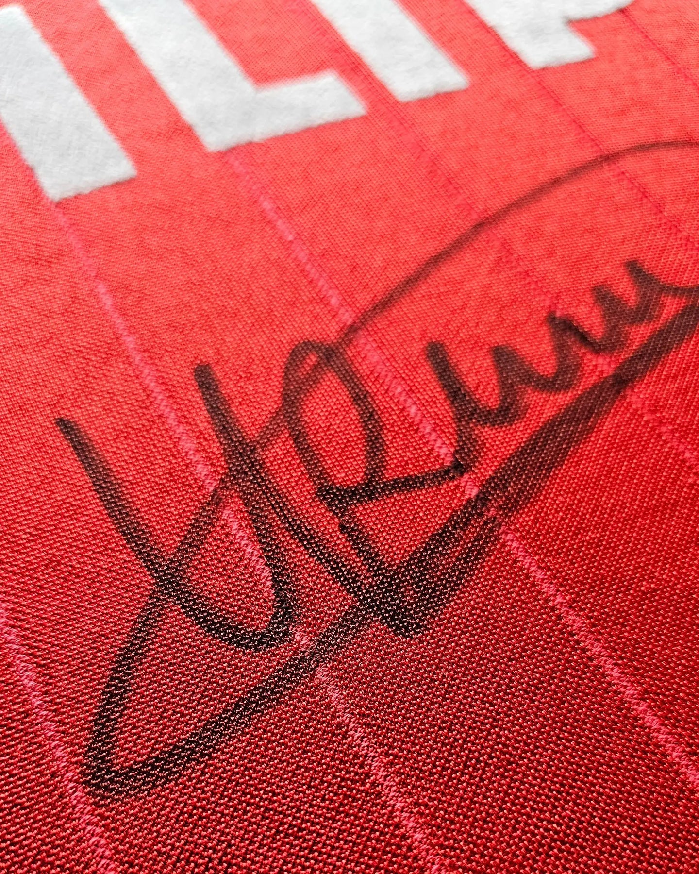 Close-up of signature on red football shirt with white lettering from Ronald Koeman.