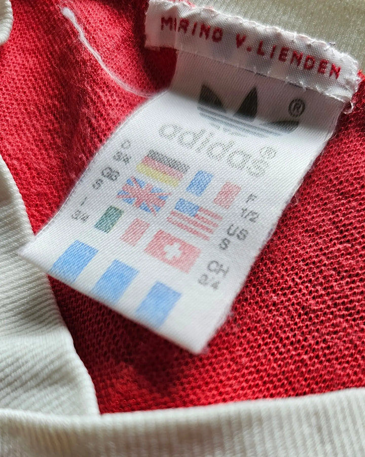 Size label with country flags and 'adidas' branding, showing care instructions.