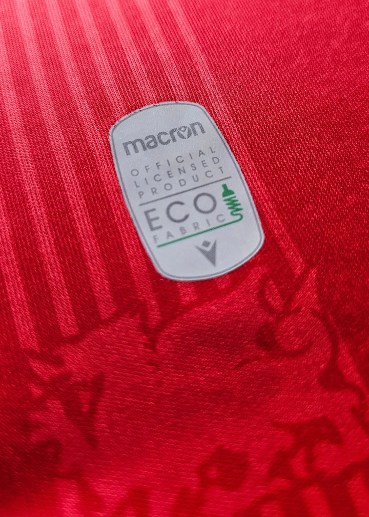 Crest detail featuring macron logo and ECO fabric label on red background.