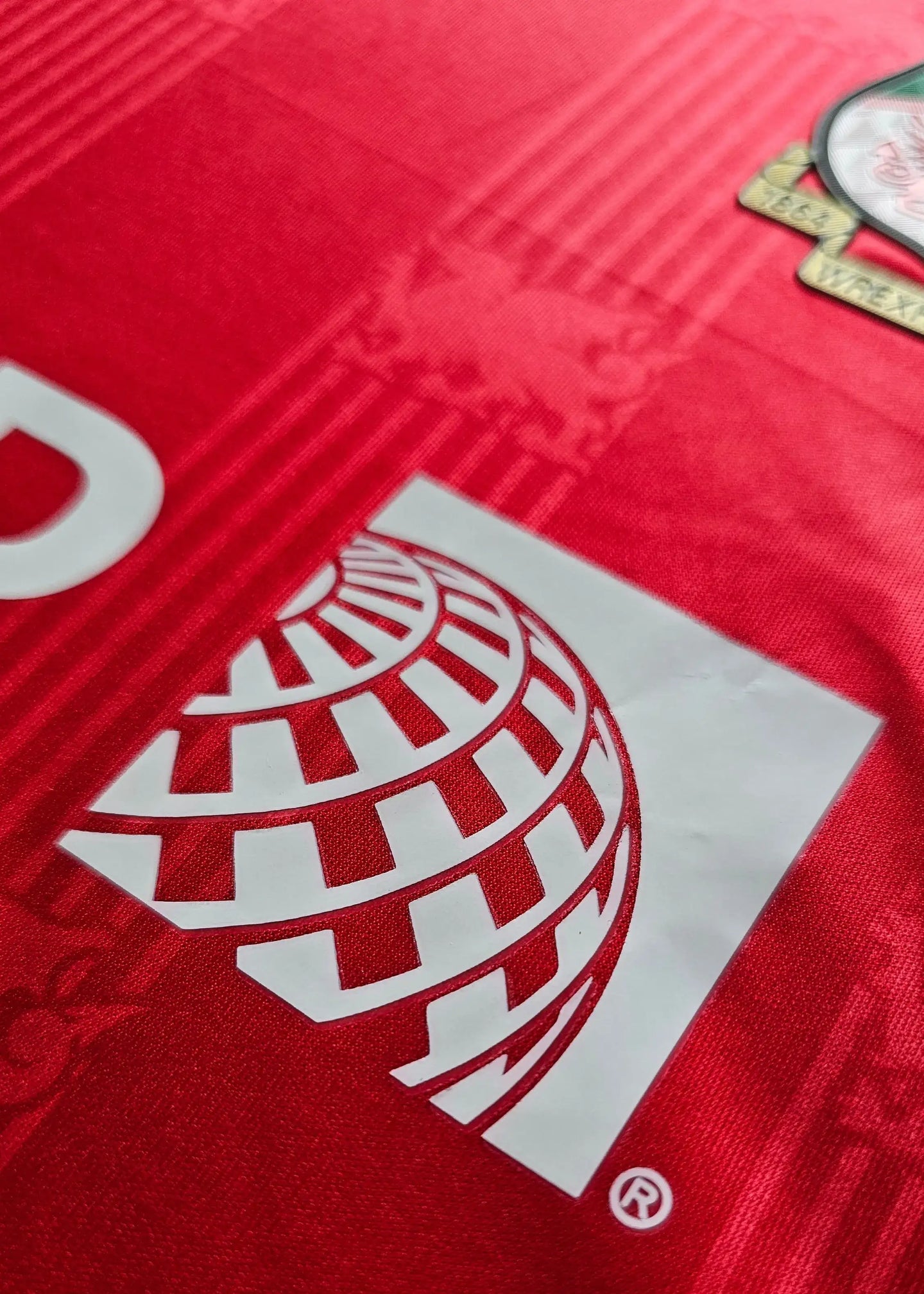 Crest detail featuring Wrexham AFC badge in red and white on a red background.