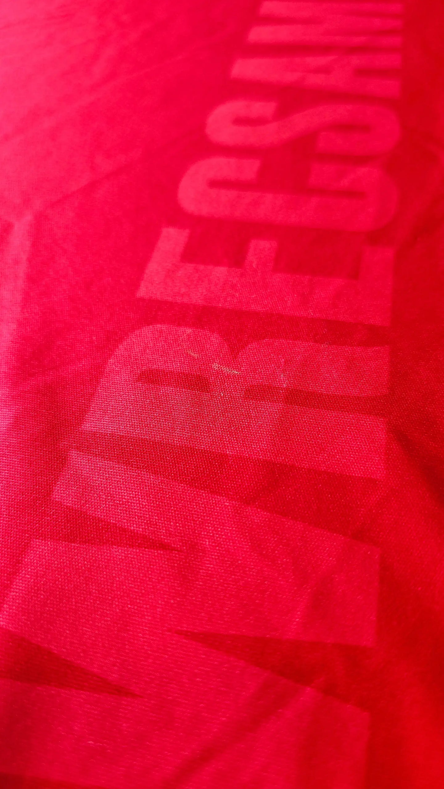Red fabric with visible Wrexham AFC text and details for signature placement.