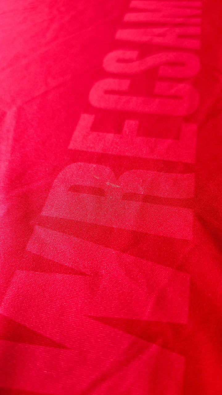 Red fabric with visible Wrexham AFC text and details for signature placement.