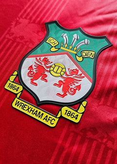 Crest detail featuring Wrexham AFC logo with two red dragons, established 1864.