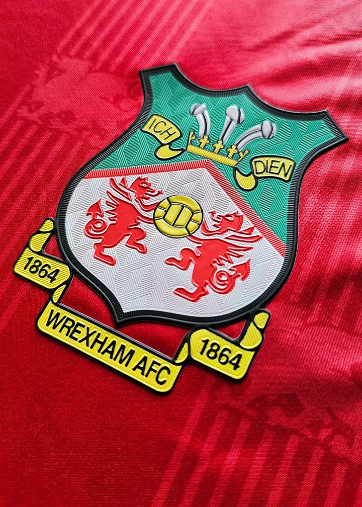 Crest detail featuring Wrexham AFC logo with two red dragons, established 1864.