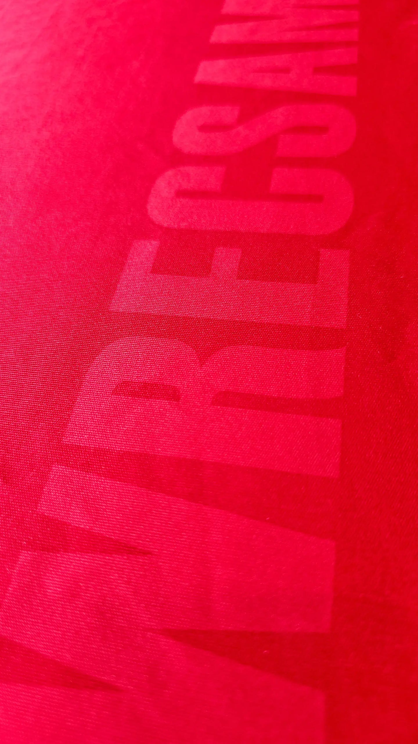 Close-up view of Wrexham AFC lettering on a red signed soccer jersey by Phil Parkinson.