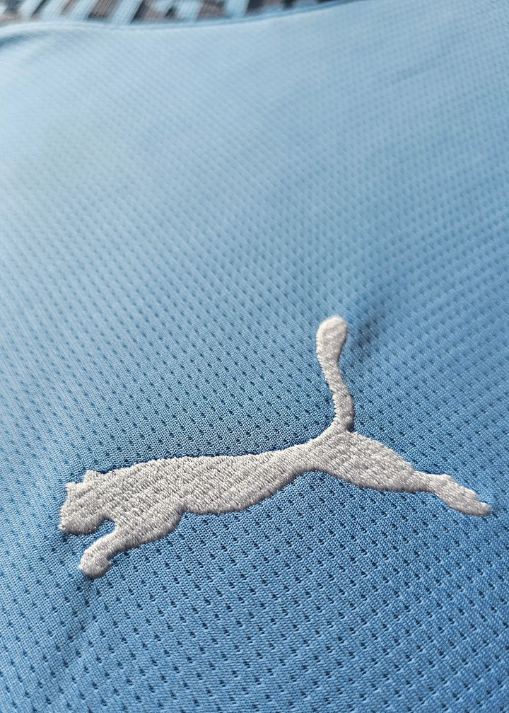 Puma logo detail on blue Manchester City 2024-25 signed football shirt.