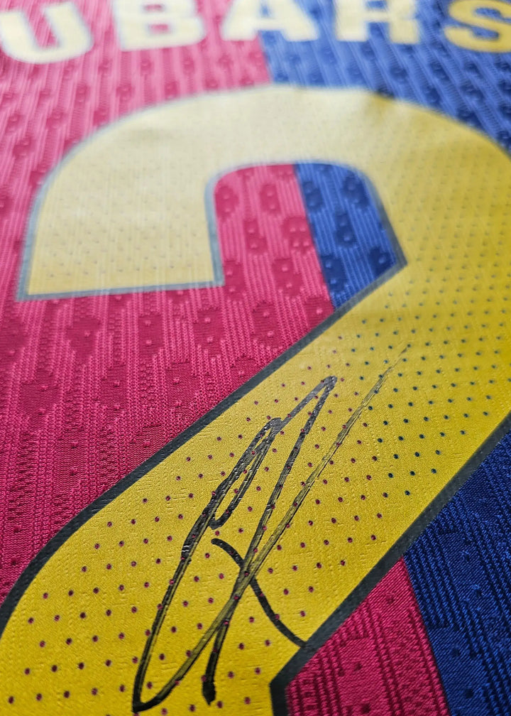 Close-up of No. 2 with signature on a Barcelona football shirt in blue, red, and yellow.
