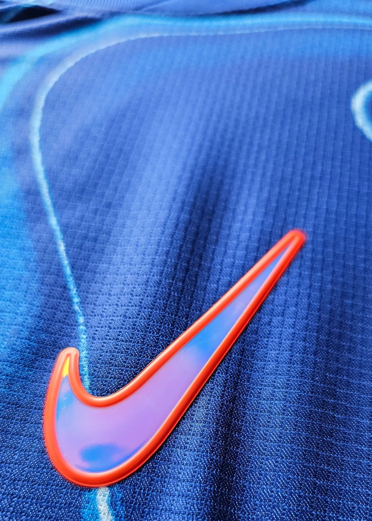 Close-up showing the blue fabric and the red Nike swoosh logo on Cole Palmer's signed football shirt.