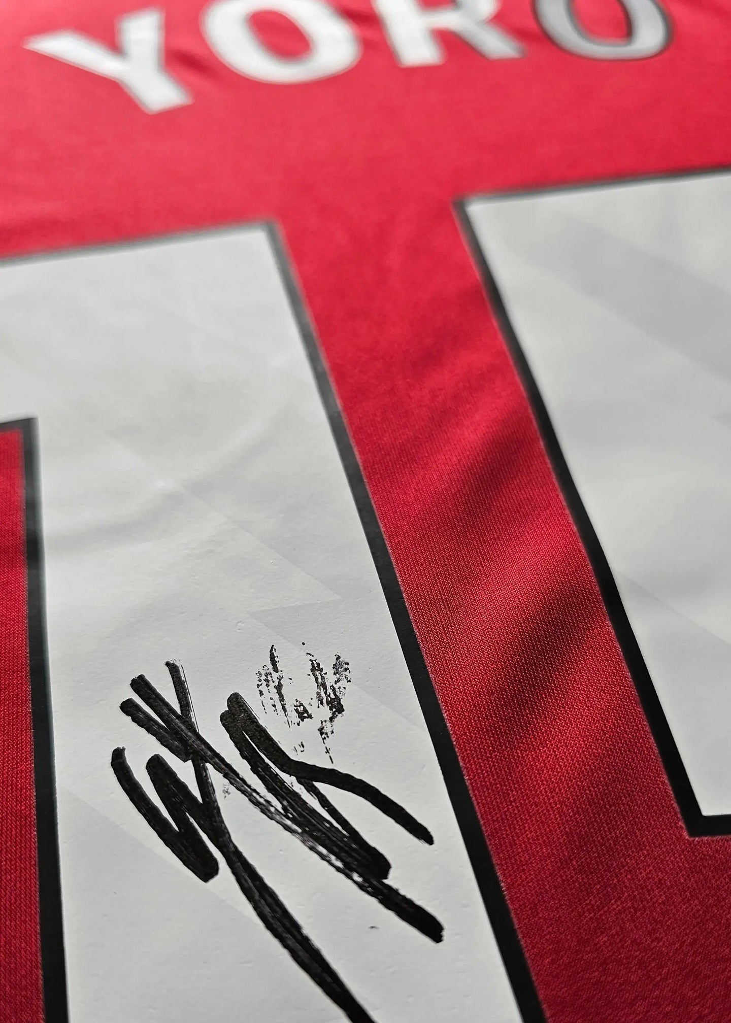Detail view showing the signature of Leny Yoro on the No. 15 Manchester United football shirt.