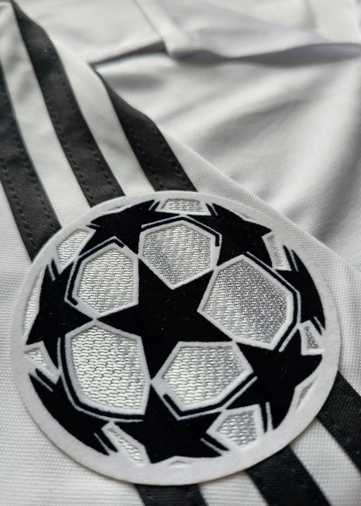 Close-up of the UEFA Champions League badge featuring black stars on a white background.