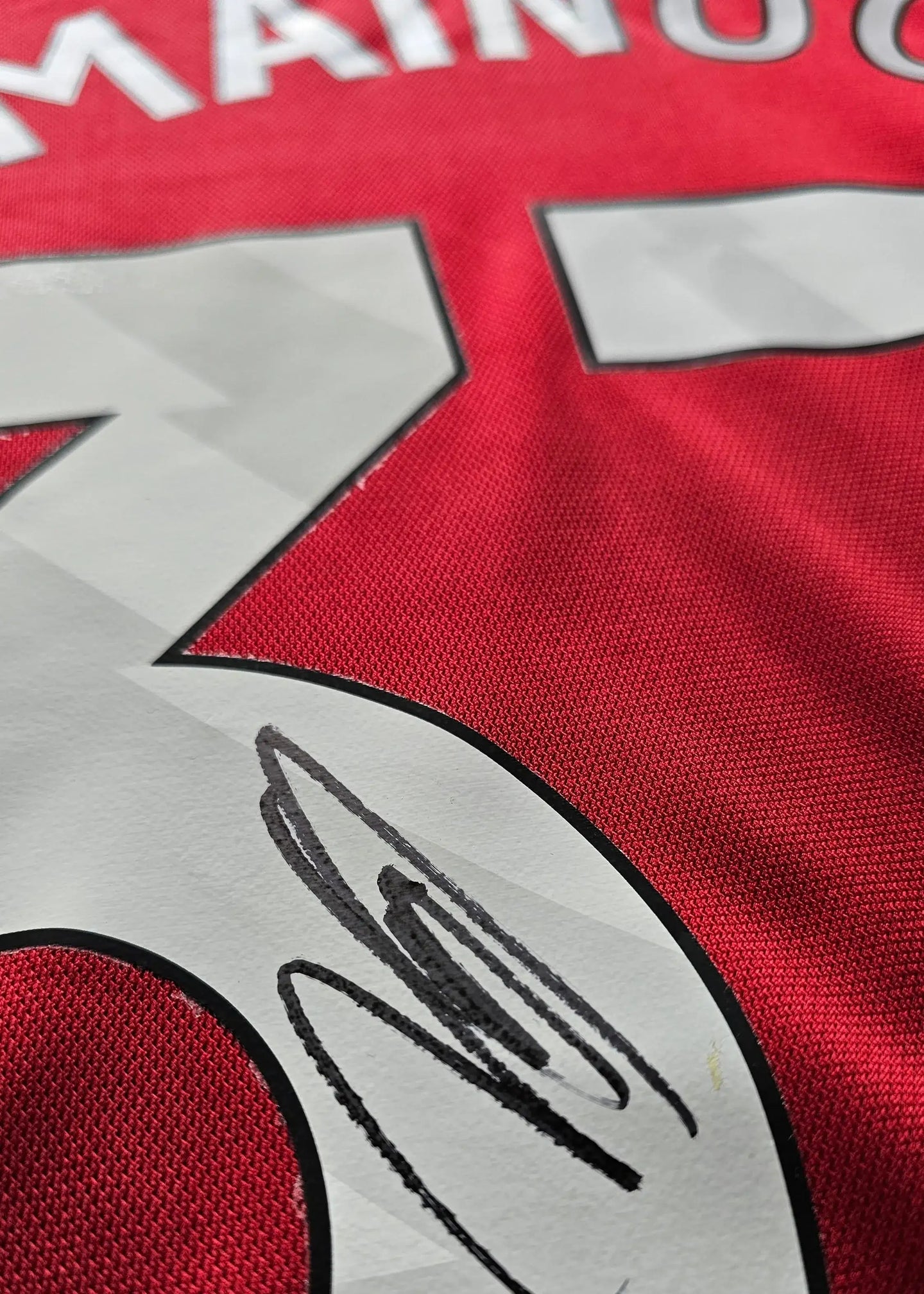 Signature detail of Kobbie Mainoo on No. 37 of Manchester United football shirt.