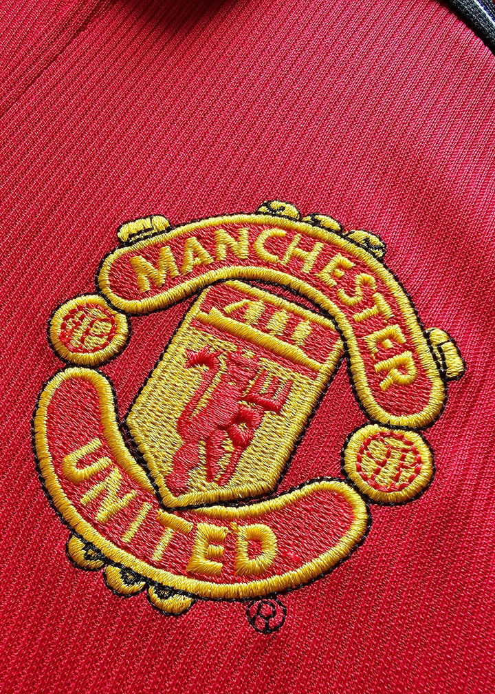 Close-up of the embroidered Manchester United crest with the text &